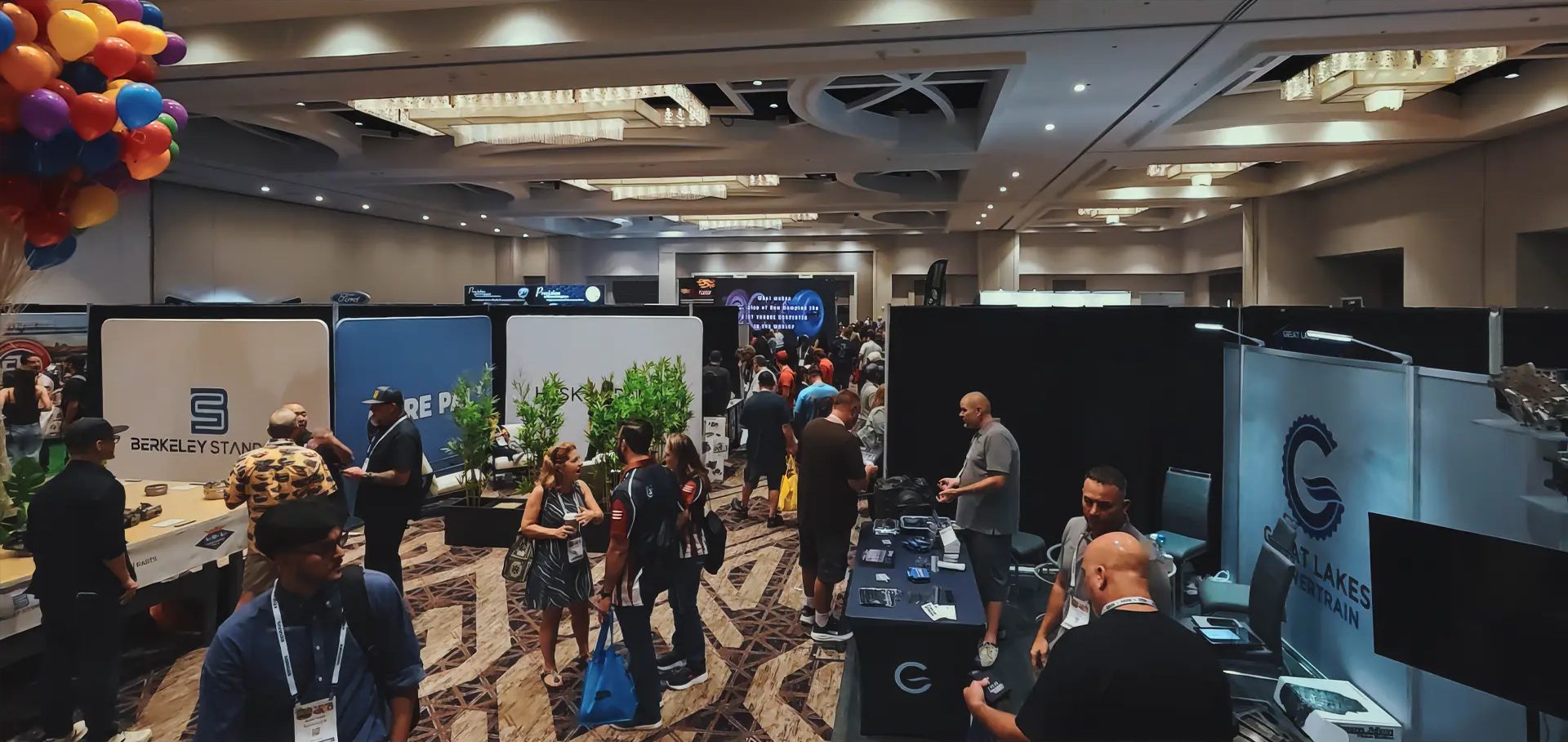 Exhibitor booths and attendees on a previous Powertrain Expo trade show floor